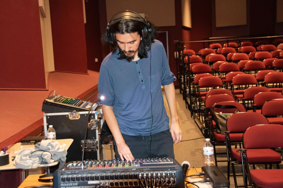 Recording Arts Student Worker Ricky Montejo manages audio for jazz band at rehearsal.