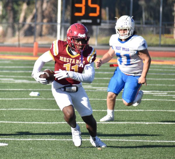 LMC wide receiver Sima Dumbaya catches a pass and runs through open space.