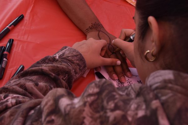 Student volunteer Manya Rana draws henna at the Diwali event.