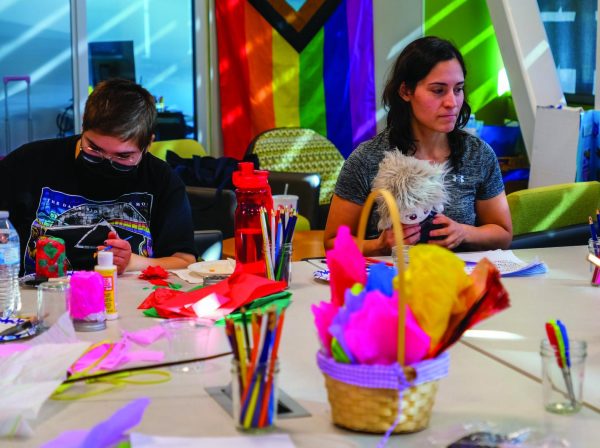 Students Emma Haddadin and Natasha Sternbergh decorate their mason jars with different colors of tissue paper.