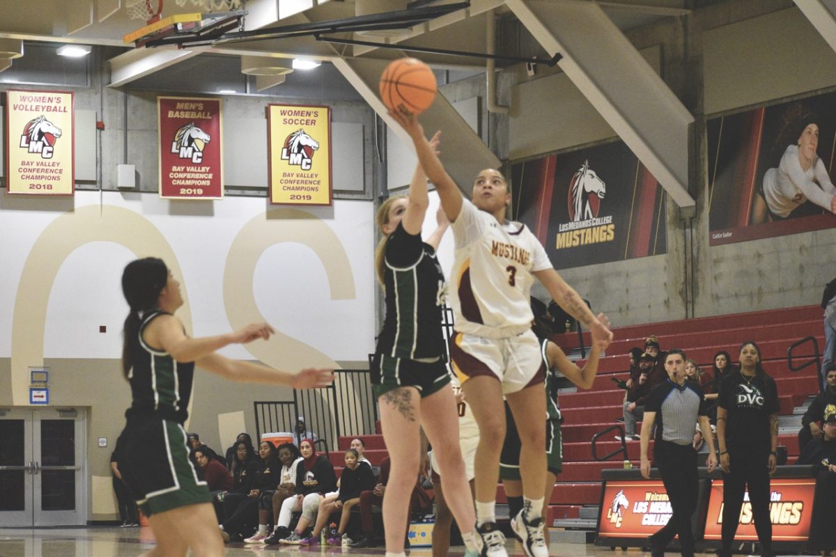 Mustang's Sa’Nia White attempts to make a basket during game.