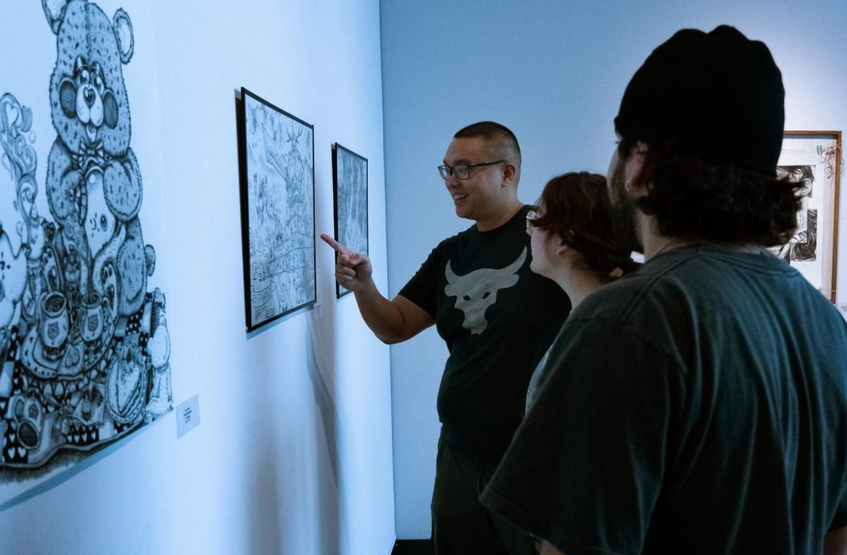 Attendants of the 2024 student art show looking at the previous works.