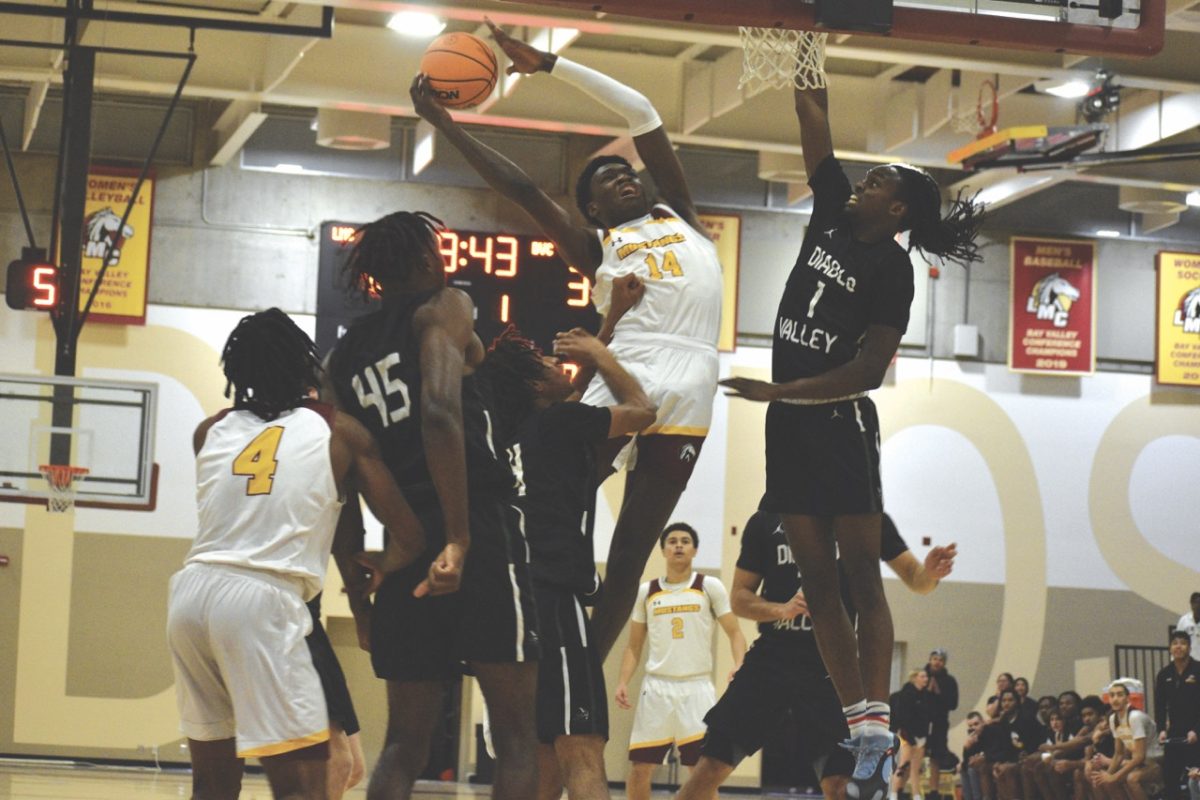 Mustangs No. 14, Tochi Onyeador, attempts to dunk basketball during game.