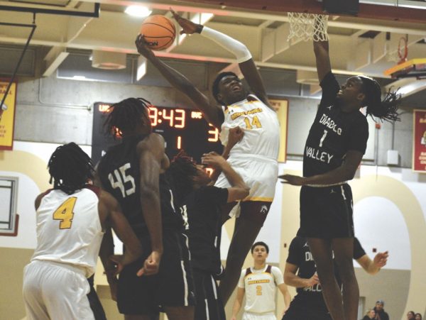 Mustangs No. 14, Tochi Onyeador, attempts to dunk basketball during game.