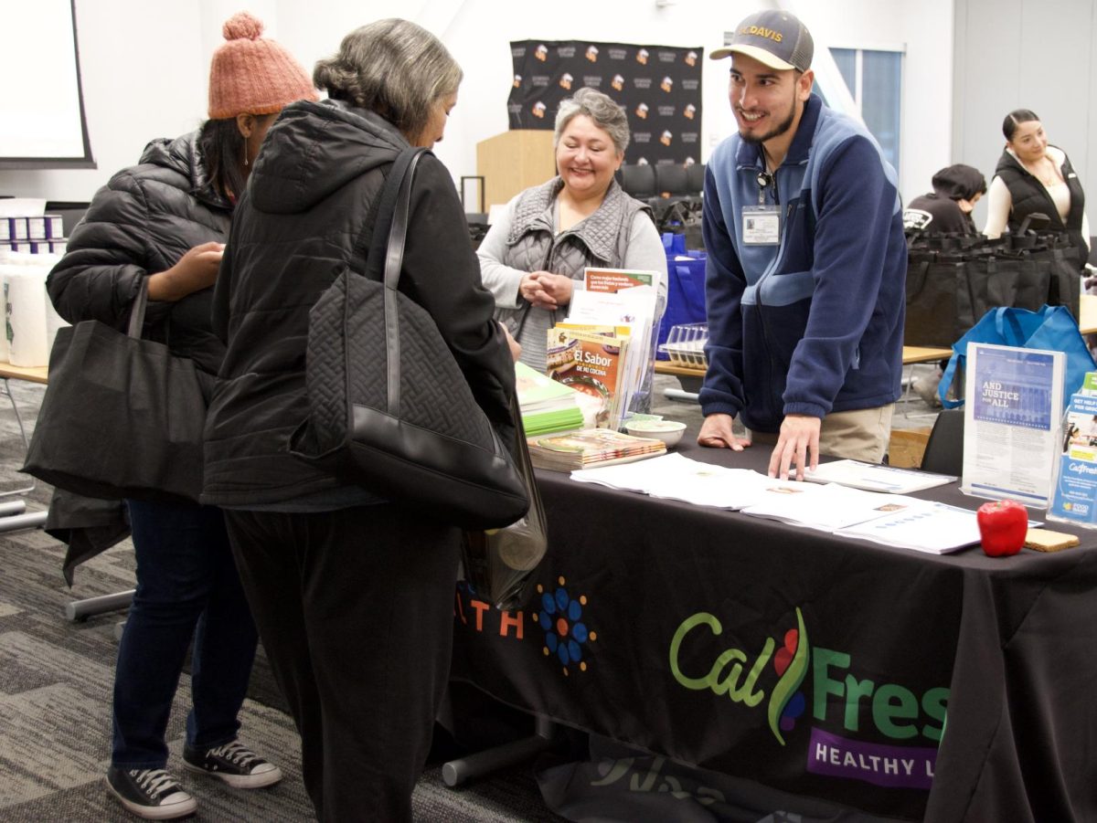 Health education specialists from Contra Costa Health Ana Villalobos and Mauricio Guerrero Villanueva share recipes to students at Basic Need's Friendsgiving Thanksgiving distribution in the Los Medanos College Student Union Conference Center Nov. 26. 