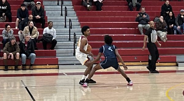 During last Friday's game No. 22 Diego Lopez scans the court for his game plan near the sideline with No. 4 Joseph Gould trying to break up his rhythm.