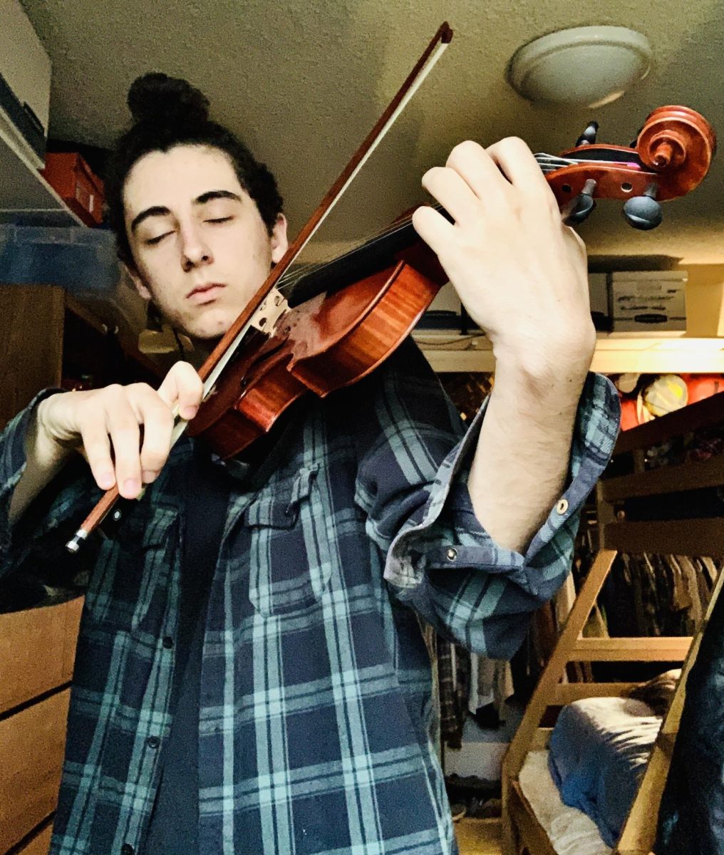 Student Michael Hummel practicing violin at home back when he was still in high school.