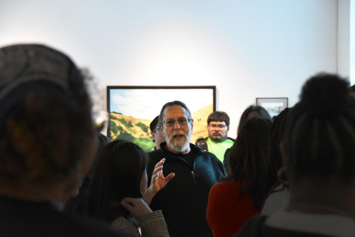 Art professor Ken Alexander gives a tour to visitors at the LMC Art Gallery, March 11. 