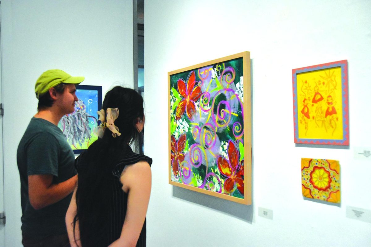 Attendees look at student art currently displayed in the Los Medanos College Art Gallery.