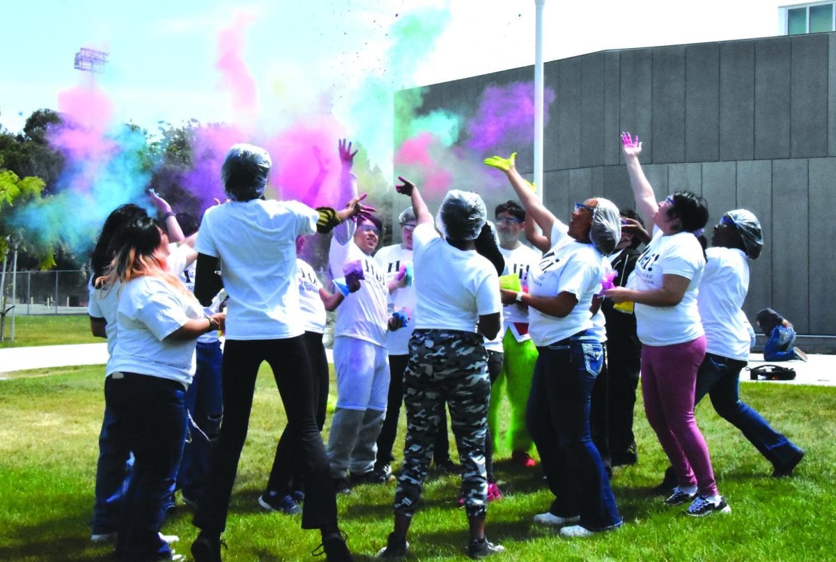 Students throw gulal in the air April 24 during the Holi event in front of the Student Union. 