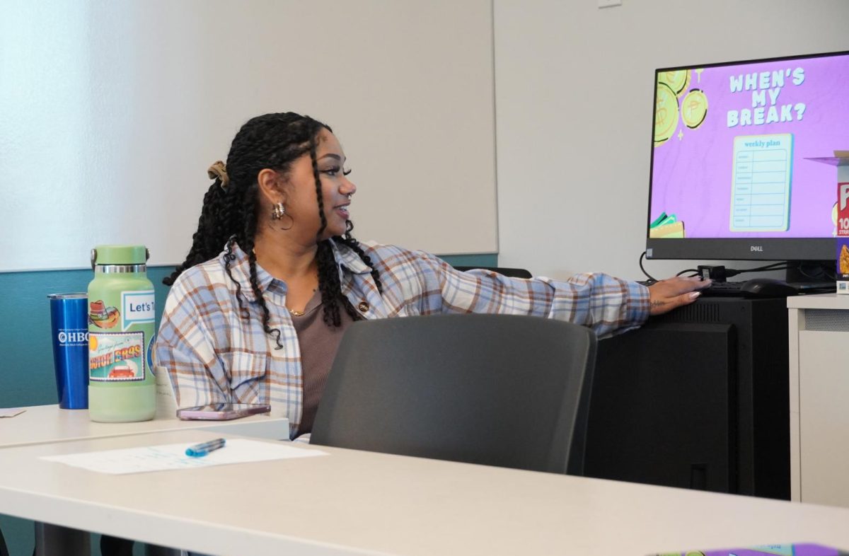 Umoja and event facilitator Erysse Green presents a powerpoint to LMC students about hustle culture.  