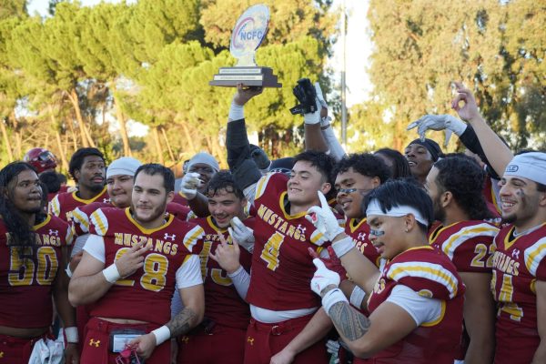 LMC Player No. 4 Sean Cervantes raises the Golden Bowl Trophy after LMC's win against Coalinga Nov. 22.