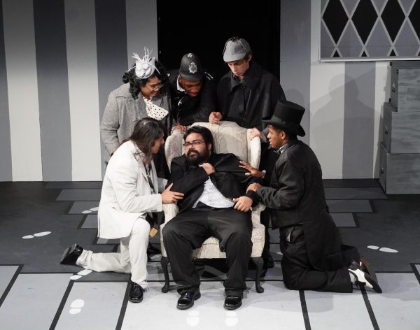 Actors Raven Figeuroa (white suit and, Alyssa Mae (behind Figeuroua) have been cast as Artax and Queen Solaria in LMC's new upcoming play "Emme and the Taking of the Woods." They are shown above with other actors in a scene from "The 39 Steps" which was presented by the drama department in December 2025.
