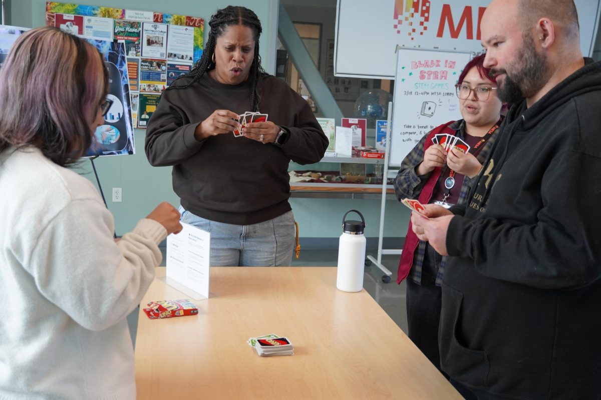 MESA Director Antoinette Corbin (Center) plays UNO with event attendees.