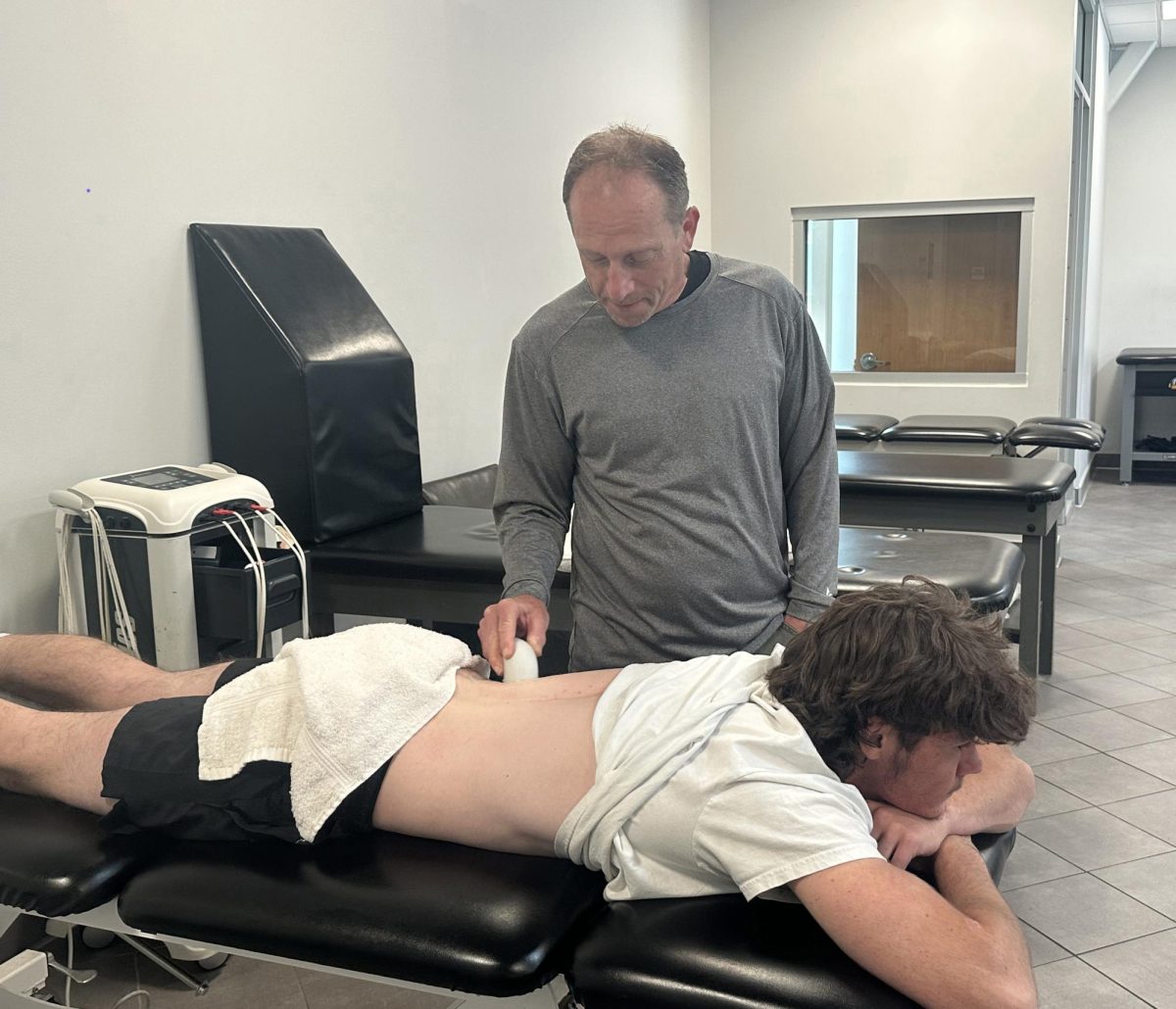 Emmett Medders receives care from athletic trainer Brian Powelson
