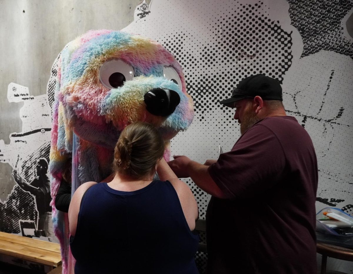 Costumer Nicole McGraw (left) with her husband (right) costumes the "Big Fluffy Monster" played by Isaac J. Kinney.